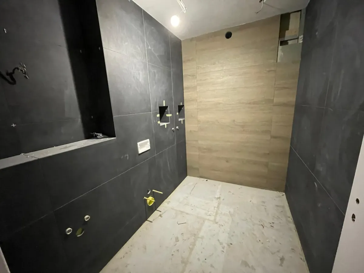 Niches murales carrelées en noir dans une douche en cours de rénovation