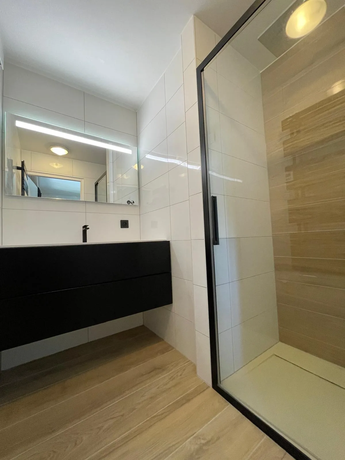 Meuble vasque noir suspendu et douche à paroi vitrée à profilés noirs