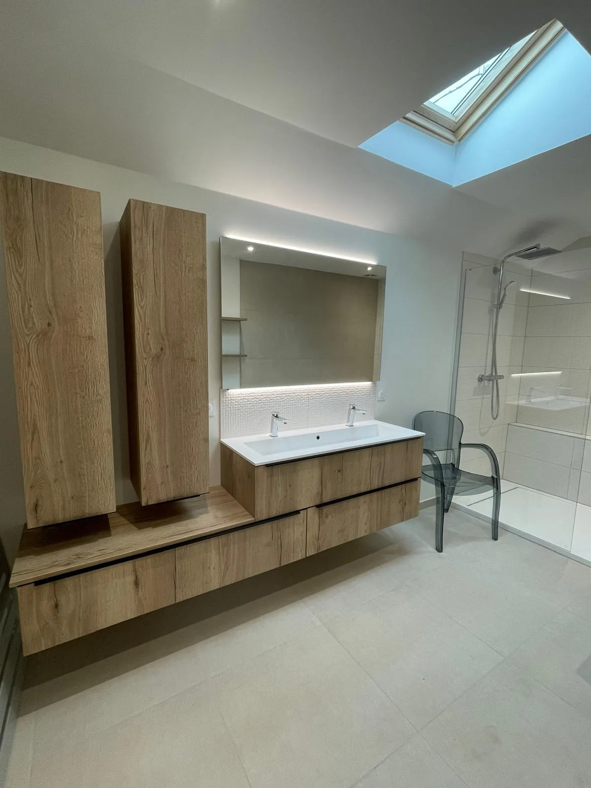 Douche à paroi vitrée à côté du meuble vasque
